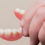 hand holding a seniors denture